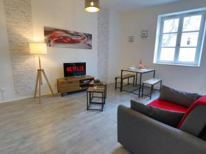 a living room with a couch and a table at Apt T2 en RDC style industriel "Cottage de Moissac" in Moissac