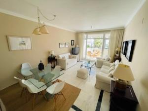 uma sala de estar com um sofá, uma mesa e cadeiras em Apart Milla de Oro Marbella em Marbella