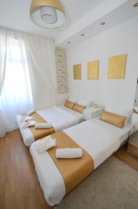 two beds in a room with white walls at Golden Garden in Yekaterinburg