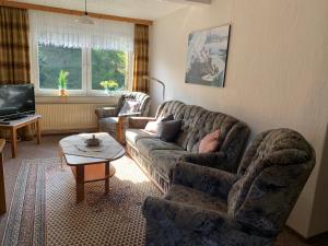 ein Wohnzimmer mit einem Sofa und einem Tisch in der Unterkunft Haus Wiesenblick in Walkenried