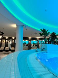 a swimming pool in a hotel with blue lights at Apartament White Sky 20 Hanza Tower- Free parking in Szczecin