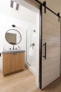 a bathroom with a sliding barn door and a sink at The Pacific Motel in Cayucos