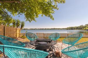 a patio with a table and chairs next to a lake at Lake House Retreat Near Downtown, Disney, Universal Studios and Airport in Orlando