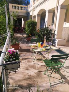 a patio with two chairs and a table and flowers at Pergolato junior in Sanremo