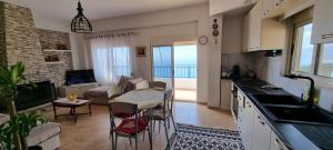 a kitchen and living room with a view of the ocean at Seaview Country House in Sarandë