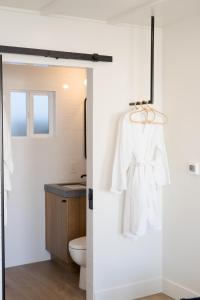 a bathroom with a white robe hanging on a door at The Pacific Motel in Cayucos