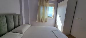 a bed in a room with a window at Seaview Country House in Sarandë