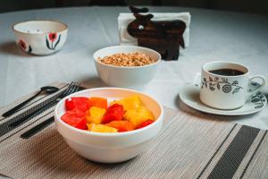 un tavolo con due tazze di caffè e un cesto di frutta di El Cocobolo Food&Rest Room 4 Bed and Breakfast WiFi AC Pkg gratis a Liberia