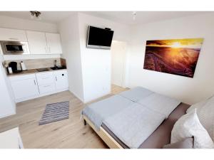um pequeno quarto com uma cama e uma cozinha em Ring Apartment am Nürburgring em Herresbach