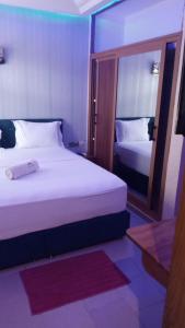 a hotel room with two beds and a mirror at HÔTEL NOAHGARDEN 2 in Cotonou