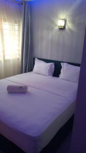 a white bed with a laptop on top of it at HÔTEL NOAHGARDEN 2 in Cotonou