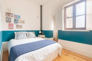 - une chambre bleue et blanche avec un lit et une fenêtre dans l'établissement Canto da Praça - No coração do centro de Aveiro, à Aveiro