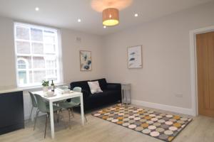 uma sala de estar com uma mesa e um sofá em Charming 1 bed Georgian Apartment em Chester