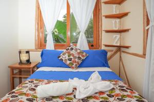 a bed with towels on it in a room with a window at La Casa en el Aire Mindo in Mindo