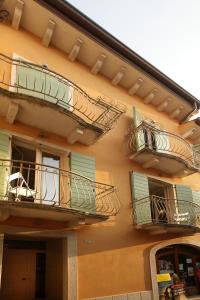 un edificio con persianas verdes y balcones. en Mariposa Apartments, en Bardolino