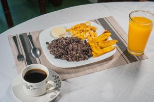 un plato de comida y una taza de café sobre una mesa en El Cocobolo Food&Rest Room 5 Bed and Breakfast WiFi AC Pkg gratis, en Liberia