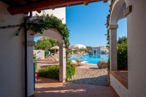 an archway leading to the pool at a resort at Hotel Resort Nuraghe Arvu in Cala Gonone