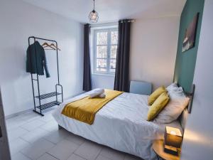 een slaapkamer met een bed met gele lakens en een raam bij T2 B and Wood "Cottage de Moissac" in Moissac