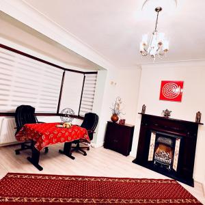 a living room with a table and a fireplace at Beautiful Double En-suite Room, separate entrance, Ilford, Central line Gants Hill, free parking in Ilford
