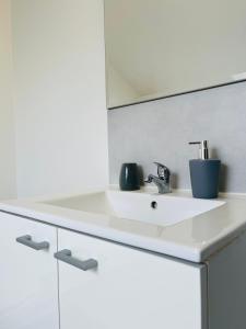 een witte badkamer met een wastafel en een spiegel bij Casa Grande in Romilly-sur-Seine