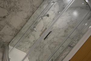 een douche in de badkamer met een glazen achterdeur bij Charming 1 bed Georgian Apartment in Chester