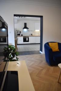 salon z niebieskim krzesłem i stołem w obiekcie [Le 8] Maison de ville élégante et tout confort w mieście Saint-Martin-la-Rivière