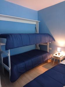 1 dormitorio con litera y paredes azules en Blue House Napoli, en Nápoles