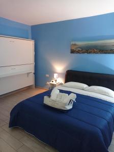 1 dormitorio azul con 1 cama grande y vestidor en Blue House Napoli, en Nápoles