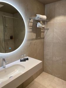bagno con lavandino e specchio di Rognan Hotel a Rognan