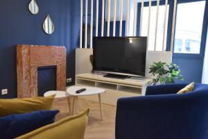 ein Wohnzimmer mit einem Flachbild-TV und blauen Wänden in der Unterkunft [Le 8] Maison de ville élégante et tout confort in Saint-Martin-la-Rivière