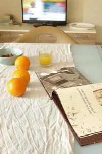 un grupo de naranjas sentadas en una mesa con un libro en Mariposa Apartments, en Bardolino