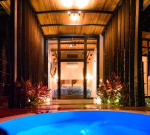 a bath tub in a room with a bedroom at Sunset Palm Lodge in San Gil