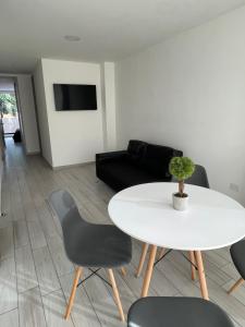 een woonkamer met een witte tafel en stoelen bij Hermoso apartamento moderno, excelente ubicación cerca al centro histórico in Bogota