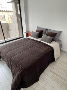 1 cama grande en un dormitorio con ventana grande en Hermoso apartamento moderno, excelente ubicación cerca al centro histórico, en Bogotá