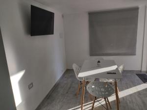 Habitación con mesa, sillas y TV. en costanera departamento en Viedma