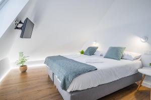 een witte slaapkamer met een bed en een tafel bij ARROKAGAIN HOME in Hondarribia