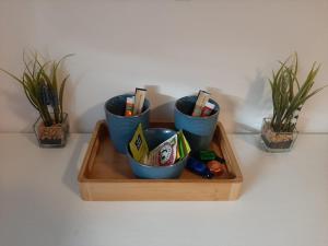 a wooden tray with three blue cups and some plants at Un beau T2 neuf à côté de Puy du Fou et la côte vendèene in Les Herbiers