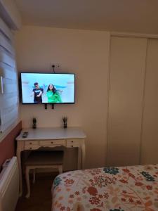 a bedroom with a desk with a tv on the wall at Un beau T2 neuf à côté de Puy du Fou et la côte vendèene in Les Herbiers