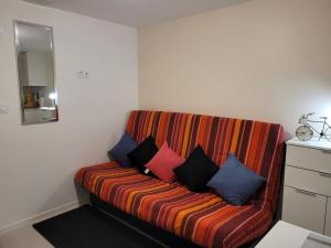 a couch with colorful pillows on it in a room at Un beau T2 neuf à côté de Puy du Fou et la côte vendèene in Les Herbiers