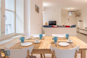 cocina y sala de estar con mesa de madera y sillas en Azzurro en Trieste