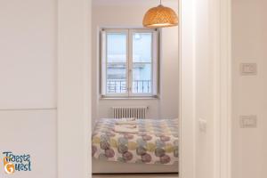 un dormitorio con una cama y una ventana en Casa Icarus, en Trieste