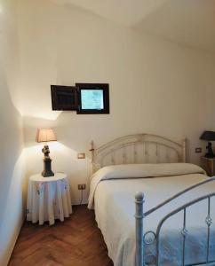 聖安托尼奧迪加盧拉的住宿－Residenza Mika，卧室配有一张床,墙上配有电视。