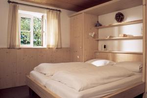 ein großes Bett in einem Zimmer mit Fenster in der Unterkunft Gästehaus Werner in Lenggries