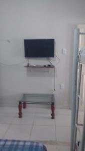 a room with a bench and a tv on a wall at Lar Jampa Beach in Cabedelo