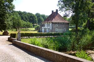 una casa vieja con un estanque delante de ella en Terborgh Budget, en Schinnen
