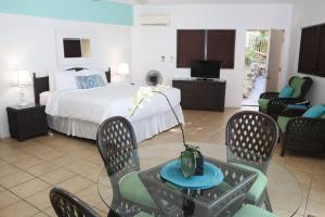 a hotel room with a bed and a table and chairs at Point Pleasant Resort in St Thomas