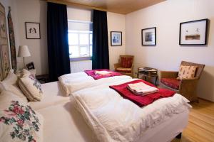 a hotel room with two beds and two chairs at Guesthouse Fludir in Fludir