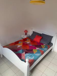 a bedroom with a bed with a colorful quilt on it at StephAppart in Le Robert