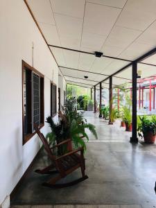Hotel Del Aserradero في ليبيريا: ممر فيه مقاعد ونباتات في مبنى