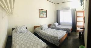 a room with two beds and a ladder and a window at Hotel Del Aserradero in Liberia